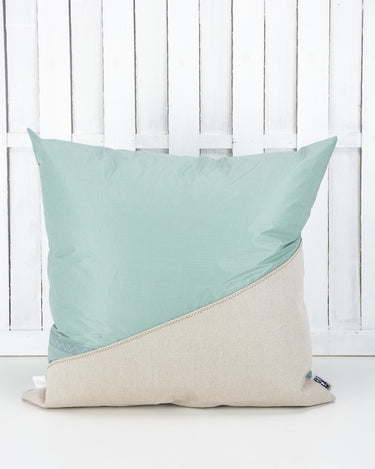 cuscino 60x60cmcolore verde salvia e beige con dettaglio pendente a forma di coda di delfino