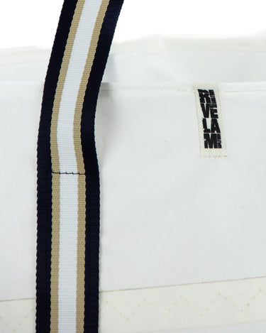 dettaglio manico borsa shopper bianca. manico in nastro a righe blu bianco e beige